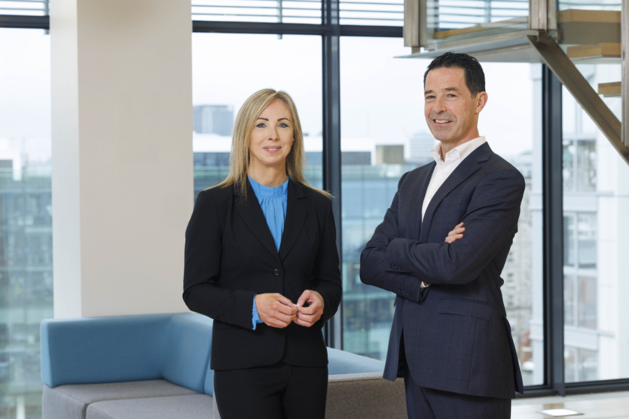 Two smiling people in business attire