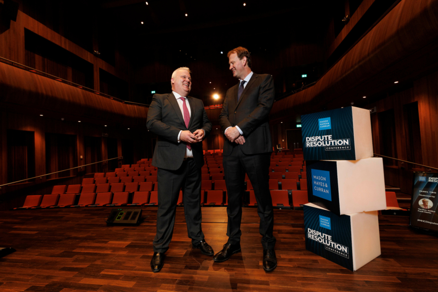 Two smiling men standing on an event stage