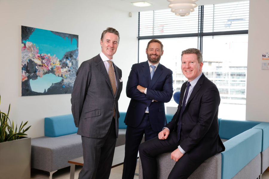 Three smiling men in suits and ties